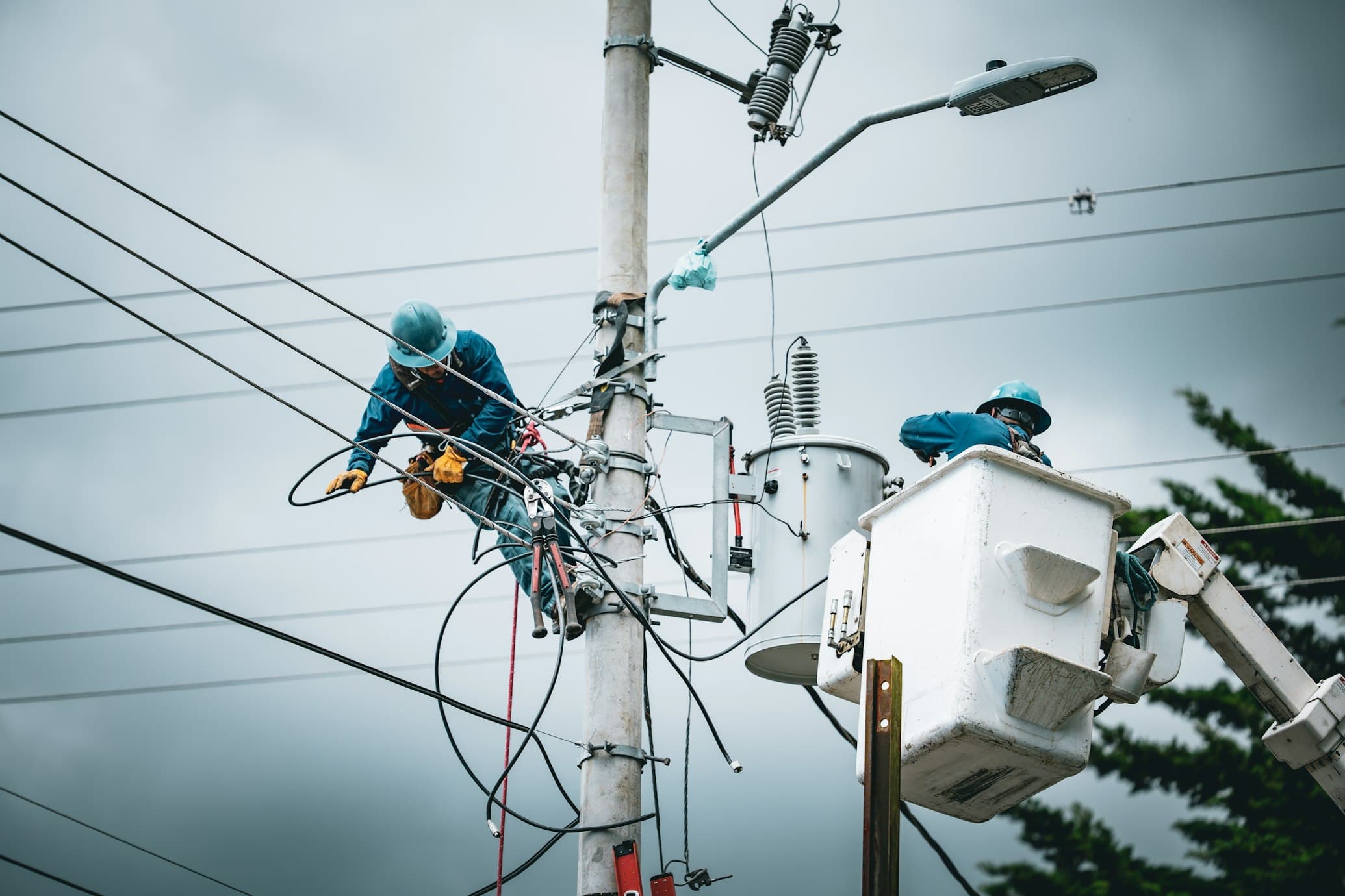 Linemen working a distribution pole from a bucket truck